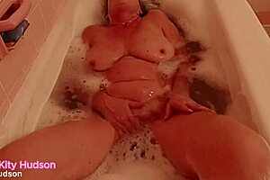 kity hudson is in the bath tub, showing off her curvy body.