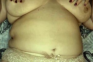 A sexy MILF shows her big boobs and shaven twat in a red dress