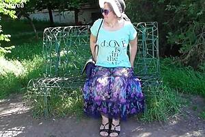 A mature woman in a see-through dress shows off her body