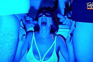 Wife sucks two hard cocks in a neon-lit threesome scene.