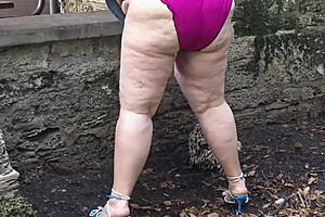 Fat mature BBW squirts close up in public park
