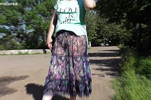 A mature woman in a see-through dress shows off her body