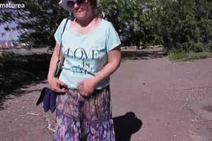 A mature woman in a see-through dress shows off her body