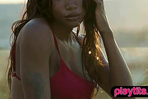 Petite ebony milf strips to expose her juicy round tits in a pool