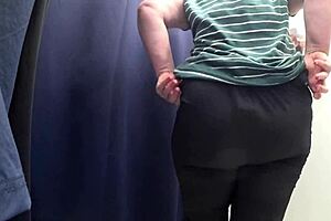 curvy woman in white panties tries on leggings in the fitting room