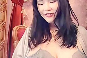 Japanese woman in blue satin performs solo on webcam.