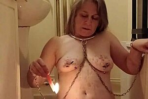 Female slave MILF sets up her solo BDSM session with candles and uro play in a homemade European video from October 28, 2024.