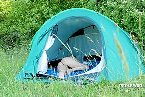 Nudist milf relaxes at the beach in her tent. She enjoys the outdoor voyeur vibe fully.