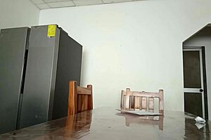 Maintenance man fixes the refrigerator as housewife oddly flashes her vagina on the desk in homemade amateur scene.