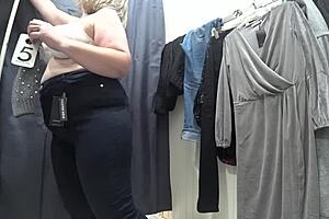 a plump milf with juicy ass in white panties and big tits in bra caught on hidden camera in public dressing room
