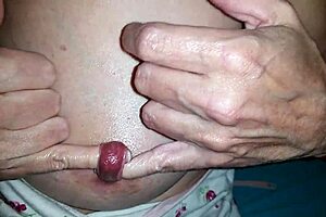 Nippleringlover, the kinky milf, fingers her extreme stretched nipple piercing. She pushes two fingers through while in bdsm slave mode.