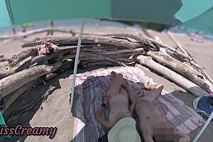 Exhibitionist wife gives outdoor amateur milf handjob to big cock on nudity beach in front of voyeur with cumshot