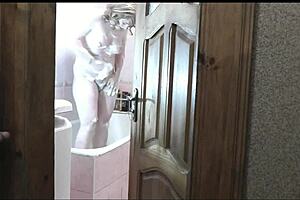 naked sexy blonde woman in bathroom without panties. Pervert man roommate watches outside masturbating cock for cumshot on old young 18+ wet pussy with natural tits.