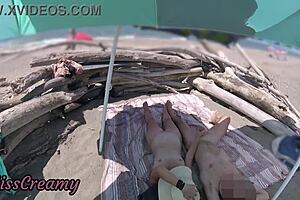 Exhibitionist wife gives outdoor amateur milf handjob to big cock on nudity beach in front of voyeur with cumshot