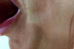 Sexy brunette milf gives oral fetish dildo blowjob with bimbo lips in close up solo session. She licks the lollipop toy softly on bed.