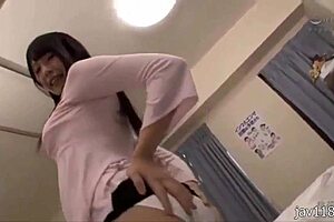 Asian nurse tends patient in hospital room.